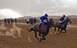 Des jockeys lors d'une course de galop hebdomadaire dans un champ, à proximité du village bédouin d'Abu Tlal, dans le sud d'Israël, près de Beer sheva, le 25 novembre 2022. (Crédit : MENAHEM KAHANA / AFP)