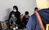 Alia Abdel-Razak, une femme privée de documents d'état civil cruciaux, s'entretient avec un avocat à son domicile de la ville de Mossoul, dans le nord de l'Irak, le 11 décembre 2022. (Crédit : Zaid AL-OBEIDI / AFP)