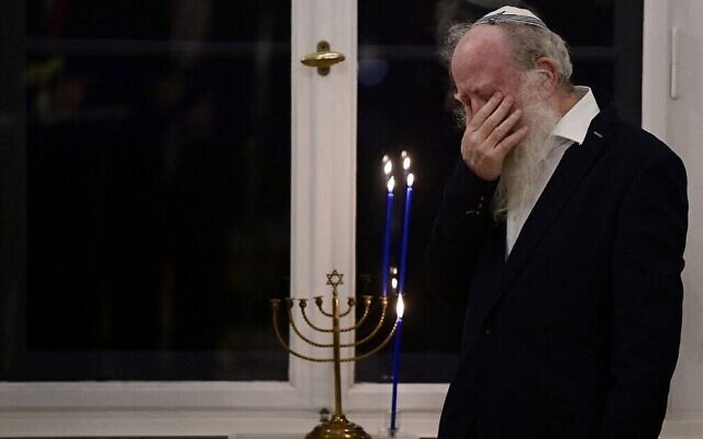Yehuda Mansbach, de la famille Posner, après avoir allumé une bougie sur la hannoukia que sa famille a sauvée d'Allemagne, lors de la célébration de Hanukkah au palais présidentiel Bellevue à Berlin, le 19 décembre 2022. (Crédit : John MacDougall/AFP) Yehuda Mansbach, de la famille Posner, après avoir allumé une bougie sur la hannoukia que sa famille a sauvée d'Allemagne, lors de la célébration de Hanukkah au palais présidentiel Bellevue à Berlin, le 19 décembre 2022. (Crédit : John MacDougall/AFP)