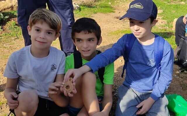 Les élèves de CM1 Alon Cohen, Liam Atias et Rotem Levnat avec une lampe à huile ancienne qu'ils ont découverte au kibboutz Parod, décembre 2022. (Crédit : Autorité israélienne des antiquités) Les élèves de CM1 Alon Cohen, Liam Atias et Rotem Levnat avec une lampe à huile ancienne qu'ils ont découverte au kibboutz Parod, décembre 2022. (Crédit : Autorité israélienne des antiquités)