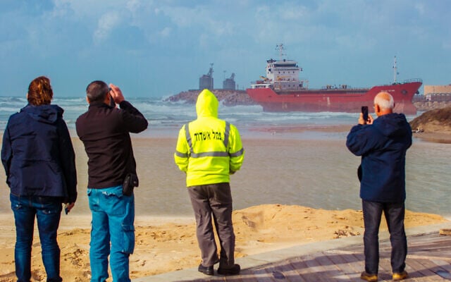 Illustration - des personnes regardent un cargo qui est arrivé au port d'Ashdod et a été emporté vers le rivage suite à une tempête à Ashdod, le 26 décembre 2019. (Crédit : Flash90) Illustration - des personnes regardent un cargo qui est arrivé au port d'Ashdod et a été emporté vers le rivage suite à une tempête à Ashdod, le 26 décembre 2019. (Crédit : Flash90)