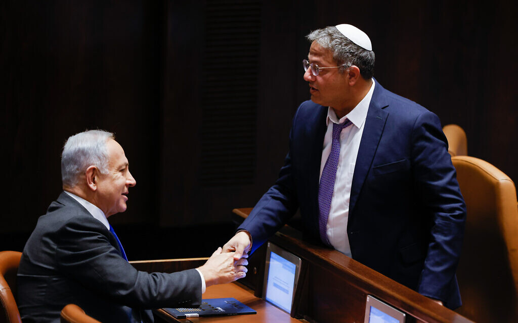 Le nouveau ministre de la Sécurité nationale, Itamar Ben Gvir, serre la main du nouveau Premier ministre Benjamin Netanyahu à la Knesset après un vote visant à étendre les pouvoirs ministériels de Ben Gvir, le 28 décembre 2022. (Crédit : Olivier Fitoussi/Flash90) Le nouveau ministre de la Sécurité nationale, Itamar Ben Gvir, serre la main du nouveau Premier ministre Benjamin Netanyahu à la Knesset après un vote visant à étendre les pouvoirs ministériels de Ben Gvir, le 28 décembre 2022. (Crédit : Olivier Fitoussi/Flash90)