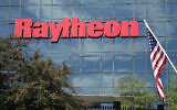 Un drapeau américain flotte devant la façade de l'installation des systèmes de défense intégrés de Raytheon, à Woburn, Mass, le 10 juin 2019. (Crédit : AP Photo/Elise Amendola, File)