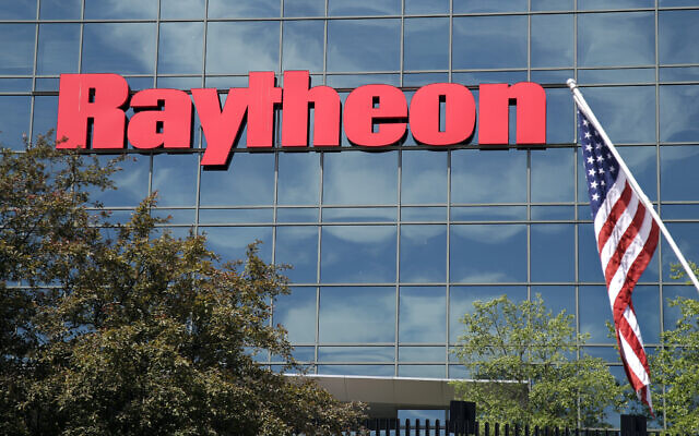 Un drapeau américain flotte devant la façade de l'installation des systèmes de défense intégrés de Raytheon, à Woburn, Mass, le 10 juin 2019. (Crédit : AP Photo/Elise Amendola, File)
