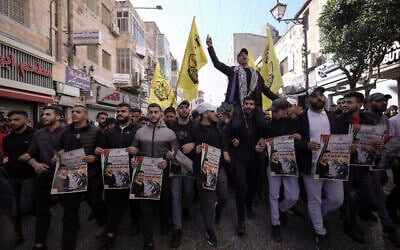 Des Palestiniens tiennent des posters du prisonnier palestinien Nasser Abu Hamid lors d'une manifestation, le 20 décembre 2022, à Ramallah, après qu'il est décédé d'un cancer du poumon en Israël. (Crédit : AP Photo/Majdi Mohammed)