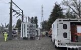 Une équipe de Tacoma Power travaille dans une station électrique endommagée intentionnellement tôt le matin de Noël, à Graham, WA. (Crédit : Ken Lambert/The Seattle Times via AP)