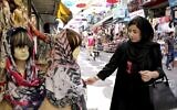 Une femme regardant un voile, sur un marché du centre de Téhéran, en Iran, le 3 juillet 2019. (Crédit : Ebrahim Noroozi/ AP Photo)