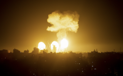 Une boule de feu et un panache de fumée s'élèvent au-dessus de bâtiments du sud de Gaza, alors que des avions de guerre israéliens frappent l'enclave palestinienne, le 4 décembre 2022. (Crédit : AFP)