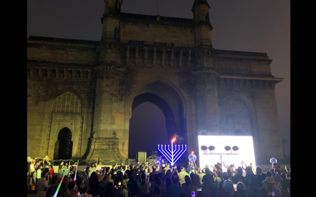  La communauté juive de Mumbai, dirigée par le Habad de Mumbai, allumant une grande menorah à la Gateway of India, à Mumbai, en décembre 2022. (Gabe Miner/JTA)