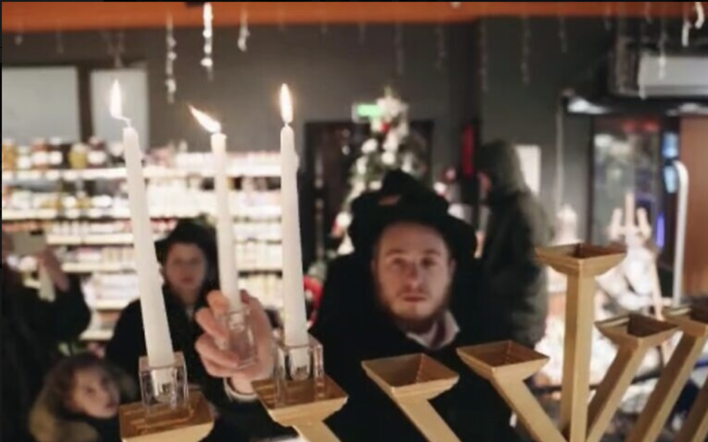 Un homme de la communauté Habad allumant une hanoukkiya le premier soir de Hanoukka, à Kharkiv, en Ukraine, le 18 décembre 2022. (Crédit : Kharkiv Choral Synagogue)