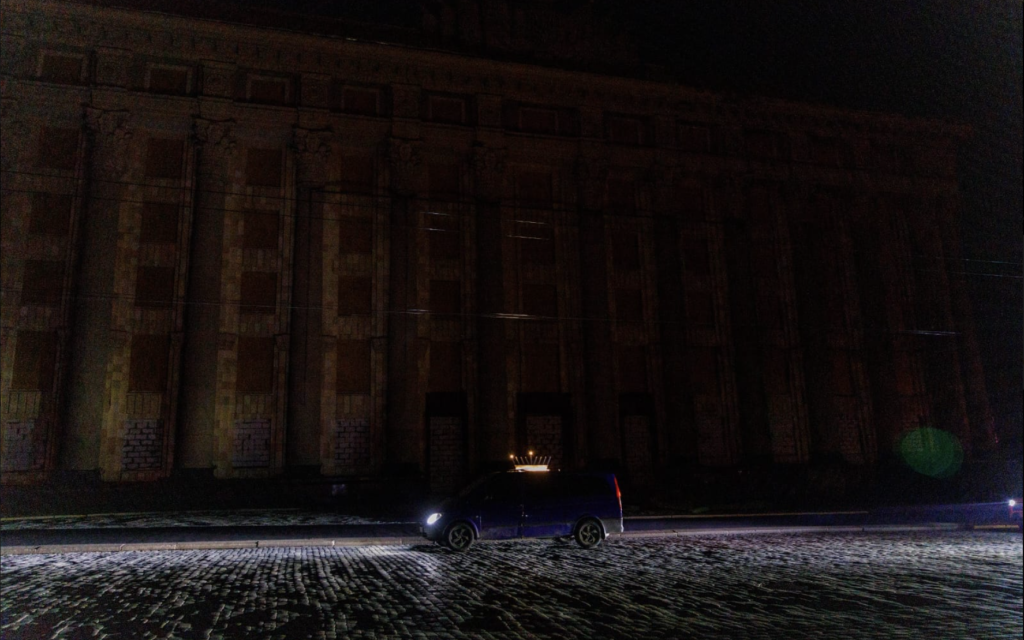 Une voiture avec une hanoukkiya fixée sur le toit  traversant un quartier sombre le premier soir de Hanoukka, à Kharkiv, en Ukraine, le 18 décembre 2022. (Crédit : Kharkiv Choral Synagogue)