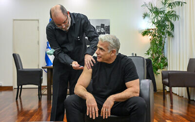 Le Premier ministre Yair Lapid se fait vacciner contre le COVID-19 à Tel Aviv, le 11 décembre 2022. (Crédit : Kobi Gideon / GPO)