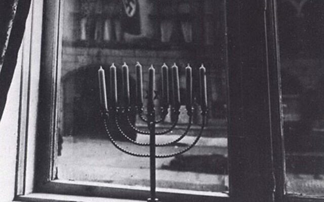 La photo emblématique d'une hanoukkia avec un drapeau nazi lui faisant face, prise par Rachel Posner, épouse du rabbin Akiva Posner de Kiel, à Kiel, en Allemagne, en 1931. (Autorisation) La photo emblématique d'une hanoukkia avec un drapeau nazi lui faisant face, prise par Rachel Posner, épouse du rabbin Akiva Posner de Kiel, à Kiel, en Allemagne, en 1931. (Autorisation)