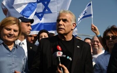 Le Premier ministre sortant Yair Lapid, au centre, s’adresse aux sympathisants de Yesh Atid réunis sur le pont du KKL à Tel Aviv, le 9 décembre 2022. (Crédit : Elad Gutman/Yesh Atid)