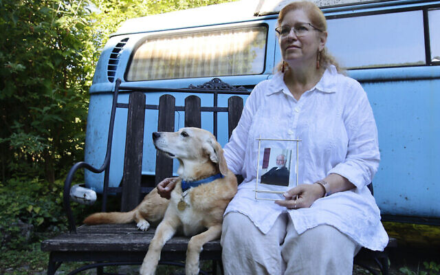 Giuliana Schnitzler, avec son chien Lucy et une photo de son père, Peter Schnitzler, chez elle à Vienne, en Autriche, le 23 juin 2022. Son père a été emmené de Vienne aux États-Unis par sa famille alors qu'il était âgé de moins de 2 ans, fin 1938. (Crédit : Raquel G. Frohlich)