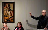 Markus Krause, commissaire des enchères, devant l'autoportrait du peintre allemand  Max Beckmann ('Selbstbildnis gelb-rosa', autoportrait jaune et rose) lors d'une vente aux enchères à Berlin, en Allemagne, le  1er décembre 2022. (Crédit : AP Photo/Michael Sohn)