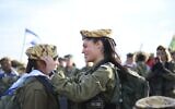 Illustration : Une lieutenante du Corps de défense des frontières plaçant un béret sur la tête d'une soldate, sur une photo non datée publiée par l'armée. (Crédit : Armée israélienne)