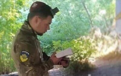 Une photo non-datée du soldat juif ukrainien Vladislav Shain en train de prier avec ses teffilines. (Autorisation :  Rabbi Moshe Azman)