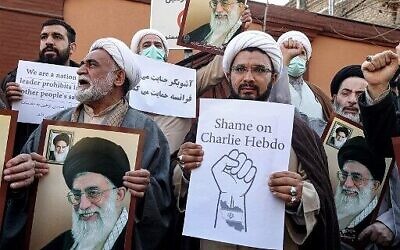 Des manifestants brandissent des images du guide suprême iranien, l'ayatollah Ali Khamenei, lors d'une manifestation contre des caricatures publiées par l'hebdomadaire satirique français Charlie Hebdo, devant l'ambassade de France à Téhéran, la capitale iranienne, le 8 janvier 2023. (Crédit : ATTA KENARE/AFP)