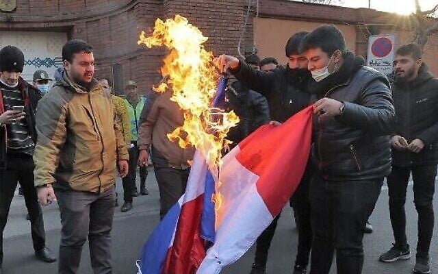 Des manifestants brûlent un drapeau français lors d'une manifestation contre des caricatures du guide suprême de la République islamique, l'ayatollah Ali Khamenei, publiées par l'hebdomadaire satirique français Charlie Hebdo, devant l'ambassade de France à Téhéran, la capitale iranienne, le 8 janvier 2023. (Crédit : ATTA KENARE/AFP) Des manifestants brûlent un drapeau français lors d'une manifestation contre des caricatures du guide suprême de la République islamique, l'ayatollah Ali Khamenei, publiées par l'hebdomadaire satirique français Charlie Hebdo, devant l'ambassade de France à Téhéran, la capitale iranienne, le 8 janvier 2023. (Crédit : ATTA KENARE/AFP)