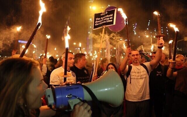 Des manifestants israéliens brandissent des torches lors d'un rassemblement contre le nouveau gouvernement du Premier ministre Benjamin Netanyahu, à Tel Aviv, le 21 janvier 2023. (Crédit : Jack Guez/AFP)