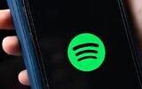 Le logo de la compagnie suédoise Spotify, géant des plateformes audio, sur un smartphone à Berlin, le 23 janvier 2023. (Crédit :  Tobias Schwarz / AFP)