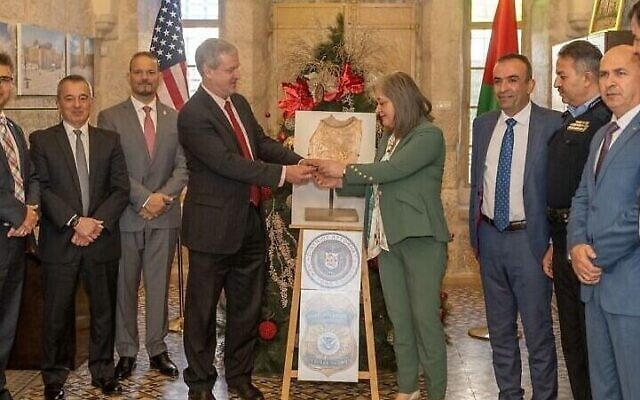George Noll, chef du Bureau américain des affaires palestiniennes, restitue une "cuillère en céramique" pillée à la ministre du Tourisme et des Antiquités de l'Autorité palestinienne, Rula Maayah, dans la ville de Bethléem, en Cisjordanie, le 5 janvier 2022. (Crédit : Bureau américain des affaires palestiniennes)