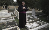 Hosam Naoum, un évêque anglican palestinien, s'arrête là où des vandales ont profané plus de 30 tombes dans un cimetière protestant historique du Mont Sion à Jérusalem, le 4 janvier 2023. (Crédit : Mahmoud Illean/AP)