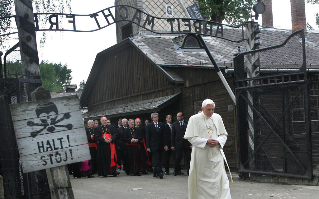 Sur cette photo du 28 mai 2006, Benoît XVI, alors pape, franchit la porte de l'ancien camp de concentration nazi d'Auschwitz à Oswiecim, en Pologne. (Crédit : Diether Endlicher/AP) Sur cette photo du 28 mai 2006, Benoît XVI, alors pape, franchit la porte de l'ancien camp de concentration nazi d'Auschwitz à Oswiecim, en Pologne. (Crédit : Diether Endlicher/AP)