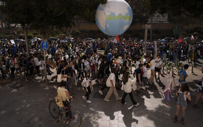 Des militants participent à une marche pour le climat appelant le gouvernement à prendre des mesures pour réduire les émissions de gaz à effet de serre afin de limiter l'impact du changement climatique à Tel Aviv, le 28 octobre 2022. (Crédit : Oded Balilty/AP)