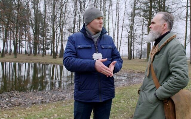 Lukasz Lipinski, un guide du musée d'État d'Auschwitz-Birkenau en Pologne, avec le réalisateur David Wilkinson, près d'un étang où les cendres des victimes étaient jetées dans l'ancien camp de la mort. (Crédit : Autorisation)