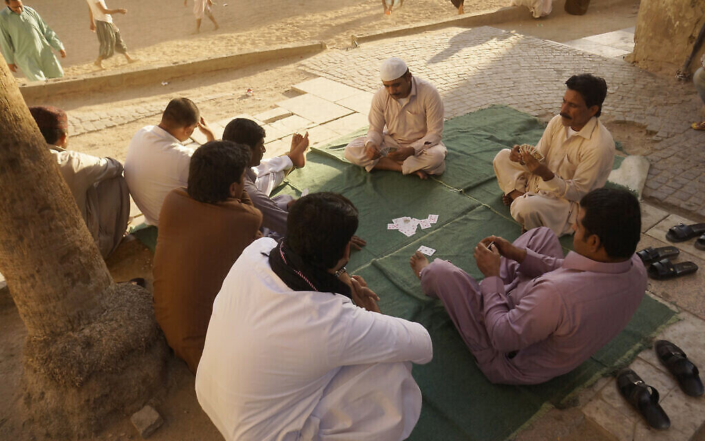 Des ouvriers se détendent en jouant aux cartes dans la vieille ville de Djeddah, en Arabie saoudite, le 24 janvier 2020. (Crédit : AP Photo/Amr Nabil, dossier)