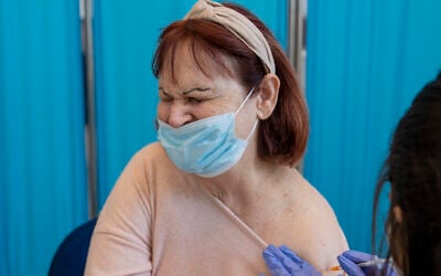 Une Israélienne reçoit sa quatrième dose de coronavirus dans une maison de retraite privée de Petah Tikva, le 4 janvier 2022. (Crédit : AP Photo/Ariel Schalit)