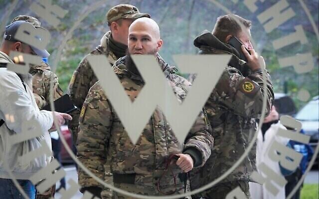 Des visiteurs portant une tenue militaire de camouflage à l'entre du "Centre Wagner", lié à l'homme d'affaires et fondateur de la milice privée du même nom, Evguéni Prigojine, lors de l'ouverture officielle des bureaux du bâtiment pendant la Journée d'unité nationale à St. Petersburg, en Russie, le 4 novembre 2022. (Crédit : AP Photo, File) Des visiteurs portant une tenue militaire de camouflage à l'entre du "Centre Wagner", lié à l'homme d'affaires et fondateur de la milice privée du même nom, Evguéni Prigojine, lors de l'ouverture officielle des bureaux du bâtiment pendant la Journée d'unité nationale à St. Petersburg, en Russie, le 4 novembre 2022. (Crédit : AP Photo, File)
