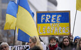 Des manifestants brandissant des drapeaux ukrainiens lors d'un rassemblement en soutien à l'Ukraine aux abords d'une réunion des ministres des Affaires étrangères européens à Bruxelles, le 23 janvier 2023. (Crédit : AP Photo/Virginia Mayo)