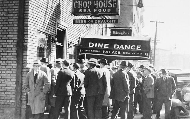 Des hommes se rassemblent autour du Palace Chop House à Newark, New Jersey, le 24 octobre 1935, le lendemain de l'assassinat d'Arthur "Dutch Schultz" Flegenheimer et de trois hommes de main. (Crédit : AP)