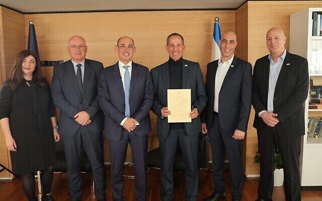 Le gouverneur de la Banque d'Israël, Amir Yaron (troisième à partir de la gauche), remet une licence bancaire conditionnelle à Shmuel Hauser (troisième à partir de la droite), président de la nouvelle banque numérique dirigée par Nir Zuk, fondateur de Palo Alto Networks. (Crédit : Banque d’Israël) Le gouverneur de la Banque d'Israël, Amir Yaron (troisième à partir de la gauche), remet une licence bancaire conditionnelle à Shmuel Hauser (troisième à partir de la droite), président de la nouvelle banque numérique dirigée par Nir Zuk, fondateur de Palo Alto Networks. (Crédit : Banque d’Israël)