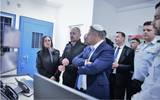 Le ministre de la Sécurité intérieure, Itamar Ben Gvir, au centre, écoutant la cheffe de l'Administration pénitentiaire israélienne, Katy Perry, à gauche, lors d'une visite à la prison de Nafha, le 6 janvier 2023. (Crédit : Administration pénitentiaire israélienne)