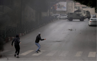 Des Palestiniens affronteant les forces de sécurité israéliennes lors d'une opération de l'armée dans la ville de Naplouse, en Cisjordanie, le 12 janvier 2023. (Crédit : AP Photo/Majdi Mohammed)
