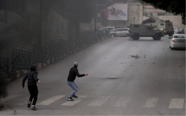 Des Palestiniens affronteant les forces de sécurité israéliennes lors d'une opération de l'armée dans la ville de Naplouse, en Cisjordanie, le 12 janvier 2023. (Crédit : AP Photo/Majdi Mohammed)