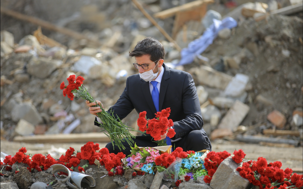  L'ambassadeur d'Israël en Azerbaïdjan, George Deek, déposant des fleurs près de bâtiments détruits dans la ville de Ganja après qu'elle a été frappée par des missiles arméniens, en octobre 2020. (Crédit : Ambassade d'Israël à Bakou)