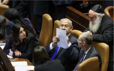 Le Premier ministre Benjamin Netanyahu s'entretenant avec d'autres membres importants de sa coalition au pouvoir lors d'une session plénière de la Knesset, le 16 janvier 2023. (Crédit : Noam Moskowitz/Knesset)