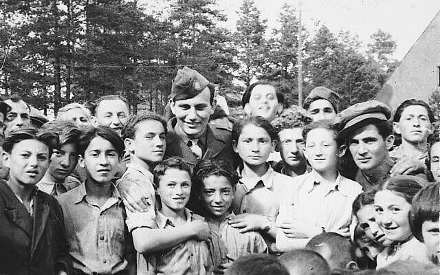 Illustration : Des enfants du camp de personnes déplacées de Foehrenwald se rassemblent autour d’un soldat américain. (United States Holocaust Memorial Museum, gracieuseté de Larry Rosenbach)