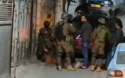 Des troupes israéliennes encerclent le corps de Samir Aslan, 41 ans, dans le camp de réfugiés de Qalandiya, près de Jérusalem, le 12 janvier 2023. (Capture d'écran : Twitter)