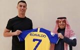 Cristiano Ronaldo brandit un maillot bleu et jaune du club Al Nassr d'Arabie Saoudite, le 30 décembre 2022 (Crédit : Al Nassr)