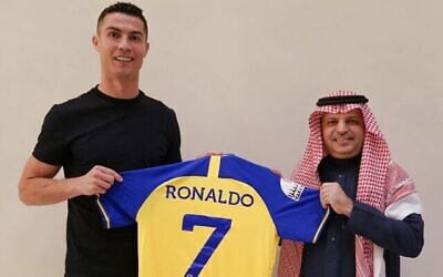 Cristiano Ronaldo brandit un maillot bleu et jaune du club Al Nassr d'Arabie Saoudite, le 30 décembre 2022 (Crédit : Al Nassr)