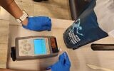 Inspection par la police des bagages de suspects qui auraient tenté d'introduire clandestinement 15 kilogrammes de cocaïne et de kétamine en Israël, à l'aéroport Ben Gurion, le 15 janvier 2023. (Crédit : Police israélienne)