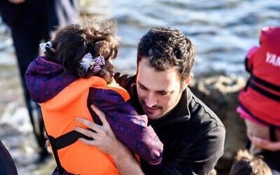 Yotam Polizer, PDG d’IsraAid, aide une réfugiée syrienne à Lesbos, en Grèce, en 2015 (Avec l’aimable autorisation d’IsraAid)