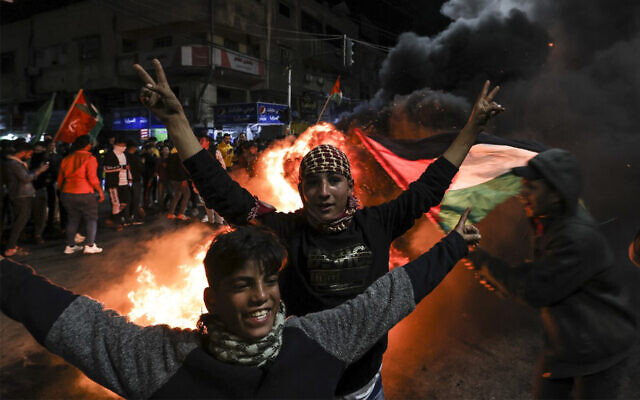 Des Palestiniens célébrant un attentat terroriste à Jérusalem qui a tué sept Israéliens dans une synagogue, dans la ville de Gaza, le 27 janvier 2023. (Crédit : Mahmud Hams/AFP) Des Palestiniens célébrant un attentat terroriste à Jérusalem qui a tué sept Israéliens dans une synagogue, dans la ville de Gaza, le 27 janvier 2023. (Crédit : Mahmud Hams/AFP)