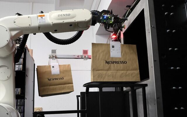 Un robot prépare un colis de capsules de café Nespresso avant sa distribution à un client, dans la réserve automatisée conçue par la société israélienne 1MRobotics, dans la ville israélienne de Tel Aviv, le 11 janvier 2023. (Crédit : JACK GUEZ / AFP) Un robot prépare un colis de capsules de café Nespresso avant sa distribution à un client, dans la réserve automatisée conçue par la société israélienne 1MRobotics, dans la ville israélienne de Tel Aviv, le 11 janvier 2023. (Crédit : JACK GUEZ / AFP)